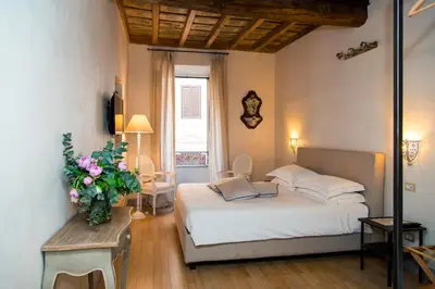a bedroom with a bed and a vase of flowers at Rome Frattina27 in Rome