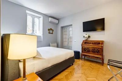 a bedroom with a bed and a tv and a table at Rome Frattina27 in Rome