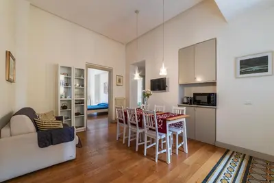 a kitchen and a living room with a table and chairs at GuestHost - Bright & Roomy Apartment x6 - Trastevere District in Rome