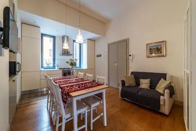 a living room with a table and a couch at GuestHost - Bright & Roomy Apartment x6 - Trastevere District in Rome