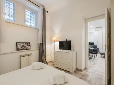 a bedroom with two beds and a television and a living room at The Best Rent - Gorgeous one-bedroom apartment near Piazza di Spagna in Rome