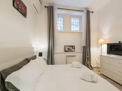 a bedroom with a white bed and a television at The Best Rent - Gorgeous one-bedroom apartment near Piazza di Spagna in Rome
