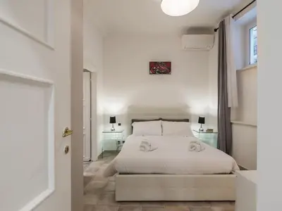 a white bedroom with a bed and a window at The Best Rent - Gorgeous one-bedroom apartment near Piazza di Spagna in Rome