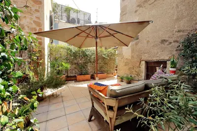 a patio with an umbrella and a couch and a chair at Ottavia Terrace in Rome