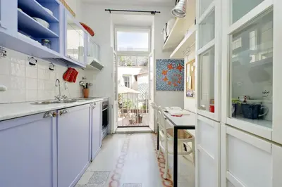 a kitchen with white cabinets and a sink at Ottavia Terrace in Rome