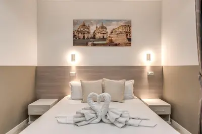 a bedroom with two towels on a bed at A Touch of Rome Guesthouse in Rome