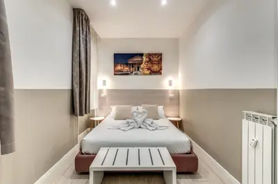 a small room with a bed and a bench at A Touch of Rome Guesthouse in Rome