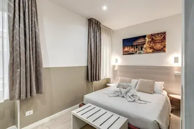 a hotel room with a bed with a teddy bear on it at A Touch of Rome Guesthouse in Rome