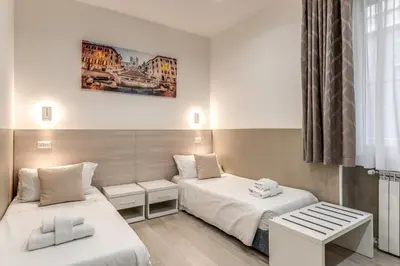 a hotel room with two beds and a window at A Touch of Rome Guesthouse in Rome