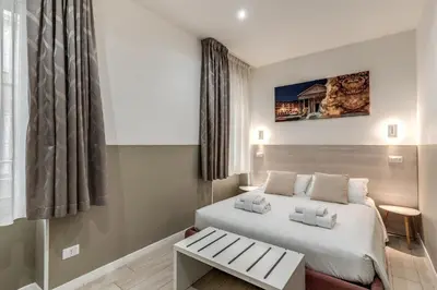 a hotel room with a bed and a table at A Touch of Rome Guesthouse in Rome