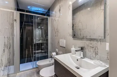 a bathroom with a sink and a toilet and a shower at A Touch of Rome Guesthouse in Rome