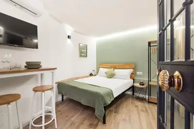 a small bedroom with a bed and a kitchen at Pellegrino 113 in Rome
