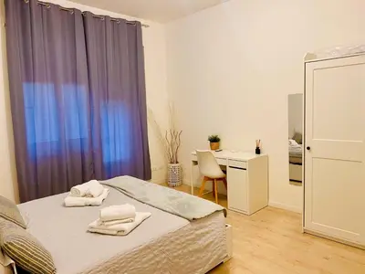 a bedroom with a bed and a desk and a window at Casa Villa Pamphili in Rome
