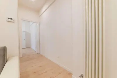 a white room with a bed and a hallway at Casa Villa Pamphili in Rome