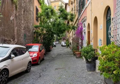 a street with cars parked on the side of a building at [Trastevere - Rome] Strategic and Comfortable Loft in Rome