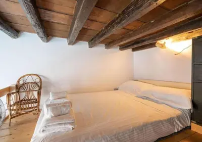 a bedroom with two beds and a chair at [Trastevere - Rome] Strategic and Comfortable Loft in Rome