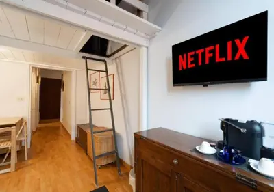 a television on a wall with a netflix sign on it at [Trastevere - Rome] Strategic and Comfortable Loft in Rome
