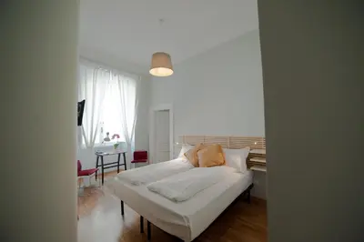 a white bed in a room with a table at Cassiodoro19 in Rome