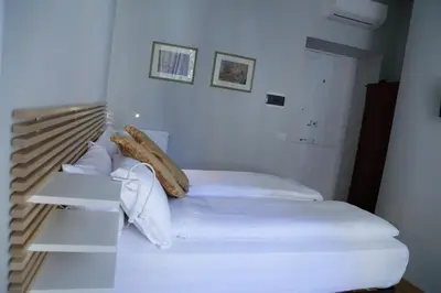 a white bed with white sheets and pillows at Cassiodoro19 in Rome