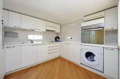 a kitchen with white cabinets and a washing machine at Suite Barberini in Rome