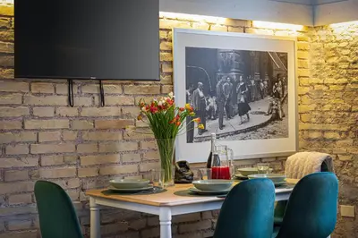 a table with chairs and a tv on a brick wall at Casa Vinia in Rome