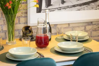 a table with plates and glasses and a bottle of red sauce at Casa Vinia in Rome