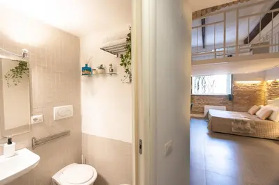 a bathroom with a toilet and a bed in a room at Casa Vinia in Rome