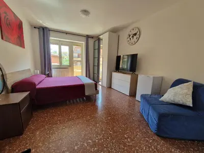 a bedroom with a bed and a couch and a tv at CorneliaGuestHouse in Rome