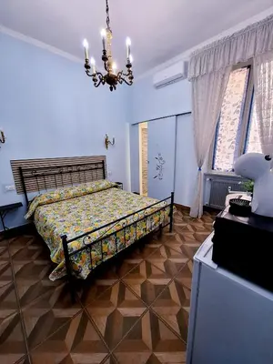 a bedroom with a bed and a chandelier at Pensiero Romano in Rome