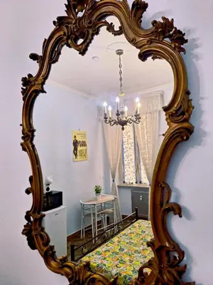 a mirror reflecting a room with a table and a dining room at Pensiero Romano in Rome