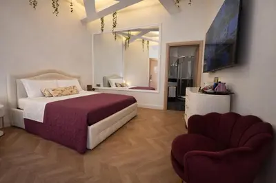 a bedroom with a bed and a chair at RomAntic Dreams Sistina Guest House in Rome