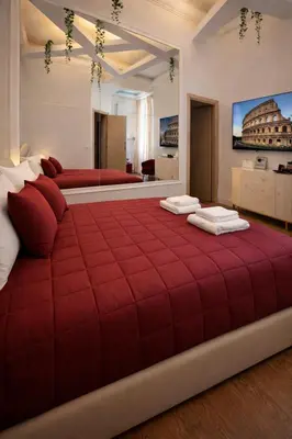 a red bed in a room with two beds at RomAntic Dreams Sistina Guest House in Rome