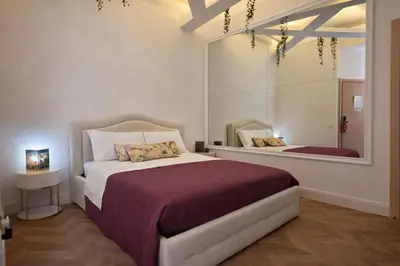 a bedroom with a large bed and a mirror at RomAntic Dreams Sistina Guest House in Rome