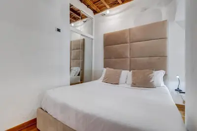 a bedroom with a large bed with a large headboard at Barberini Exclusive Loft in Rome