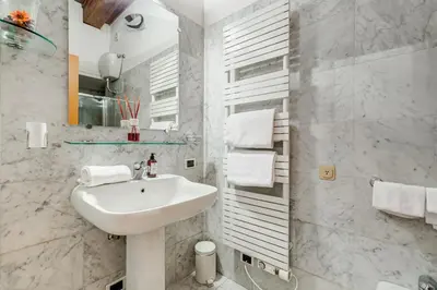a white bathroom with a sink and a mirror at Barberini Exclusive Loft in Rome