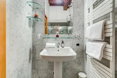 a white bathroom with a sink and a mirror at Barberini Exclusive Loft in Rome