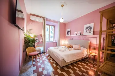 a bedroom with pink walls and a bed in a room at Telesio Suite in Rome