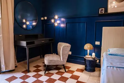 a bedroom with a mirror and a chair and a desk at Telesio Suite in Rome