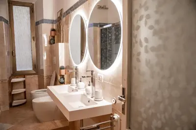 a bathroom with a sink and a toilet and a mirror at Telesio Suite in Rome