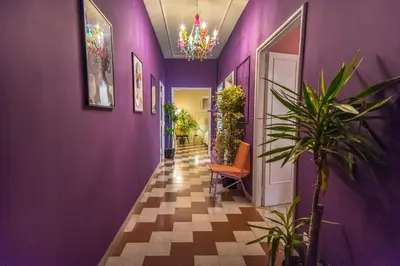 a hallway with purple walls and plants and a chandelier at Telesio Suite in Rome