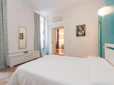 a white bedroom with a large bed and a window at Sistina 143 A-B-C in Rome