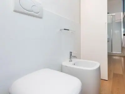 a white bathroom with a toilet and a sink at Sistina 143 A-B-C in Rome