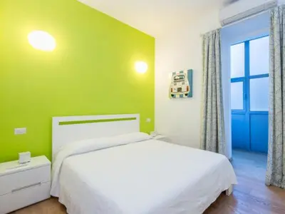 a bedroom with a white bed and a green wall at Sistina 143 A-B-C in Rome