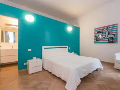 a bedroom with a large white bed and a blue wall at Sistina 143 A-B-C in Rome
