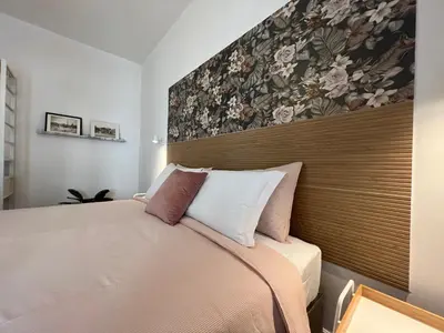 a bedroom with a bed with a large headboard at Appartamento Millelire in Rome
