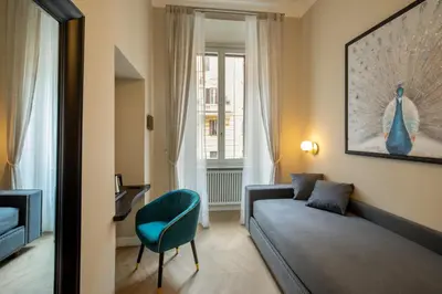 a room with a couch and a chair and a window at Porta Castello Suites in Rome