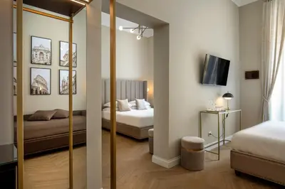 a hotel room with two beds and a mirror at Porta Castello Suites in Rome