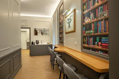 a bar in a room with chairs and books at Porta Castello Suites in Rome