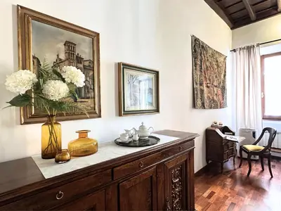a living room with a table with a vase of flowers at Casa Lovera in Vaticano in Rome