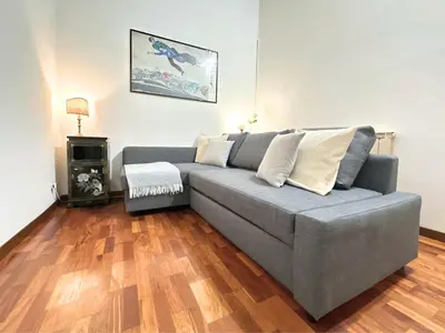 a gray couch in a living room with wooden floors at Casa Lovera in Vaticano in Rome